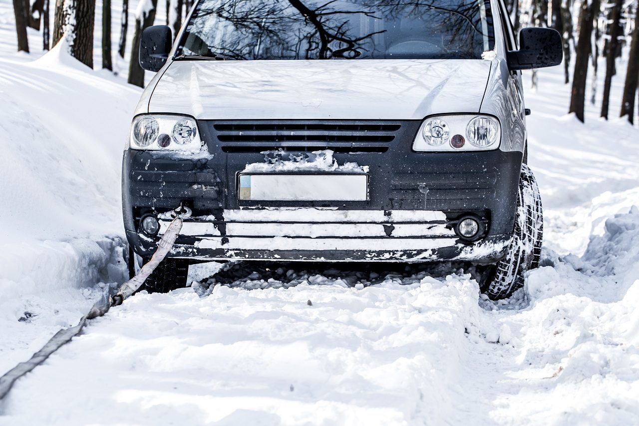Vehicle stuck deep in snow with a tow strap hooked to the front